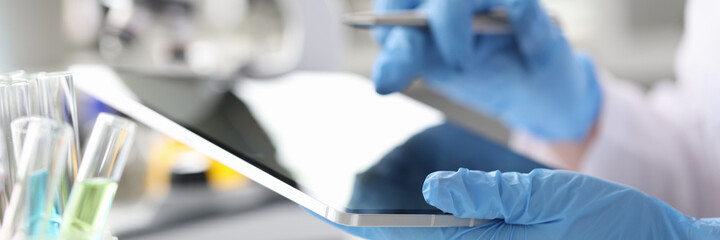 Scientist chemist enters results of research into tablet closeup