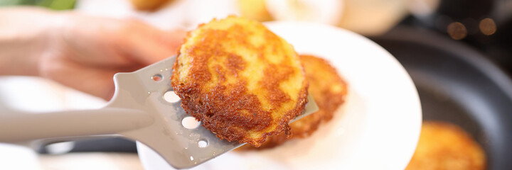 Delicious golden yellow potato pancakes in frying pan