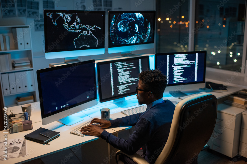 Aufkleber Young contemporary software developer working with decoded data while sitting in front of computer monitor in office at night