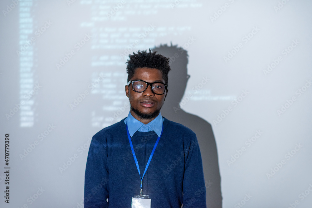Poster Young confident it-manager or software developer standing against interactive screen with decoded data