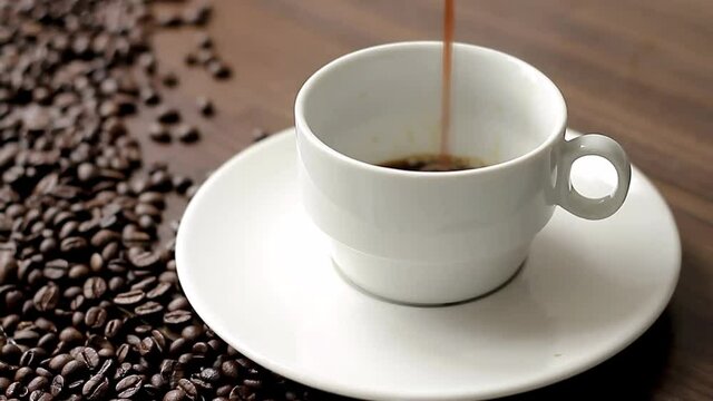 cup of hot black coffee on a table with coffee beans on a table stock video