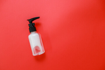 Covid 19 warning and sanitizer over red background.