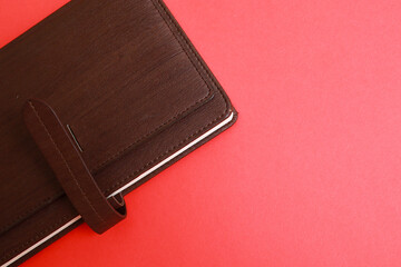 Leather cover for a small note book over red background