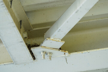 A bird's nest on a metal structure under the roof.