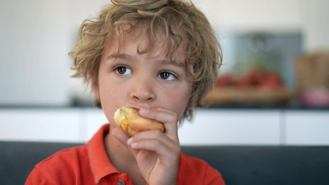 Little boy eating bread carb. Child eats piece of bread for breakfast
