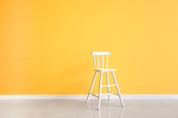 Modern chair near yellow wall