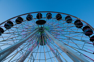 Part of Ferris wheel on blue background night sky. 