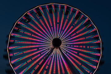Part of Ferris wheel on blue background night sky. Long exposure.