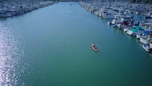 aerial footage, drones flying following a small boat, and nearby are boats parked