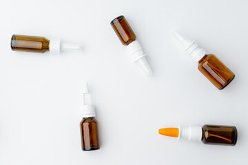Small glass bottles with medication on white background flat lay