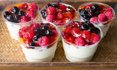 Fruit yogurt has strawberry raspberry blueberry canberry and honey greek white clean In bowl on a wooden background from top view.
