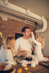 Happy family - Mother, father and daughter play and cook Christmas cookies in the loft-style kitchen