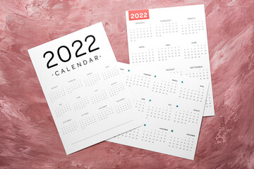 Different paper calendars for year 2022 on color background