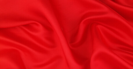 Fototapeta na wymiar Red satin or silk fabric backdrop. Beautiful wallpaper, wedding background or design element. 
