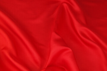 Red satin or silk fabric backdrop. Beautiful wallpaper, wedding background or design element.	