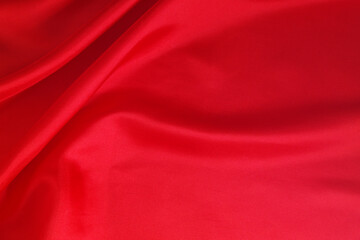 Fototapeta na wymiar Red satin or silk fabric backdrop. Romantic and wedding background. 