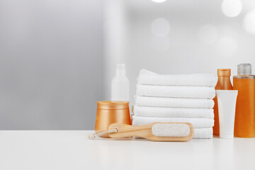 Spa still life with towels and skincare cosmetics against blurred background