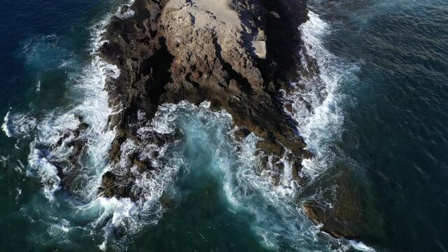 Drone looking down strong waves crashing into the rocks. Tenerife 