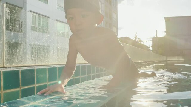 Little preschool boy learnning swimming in pool outdoor exercise