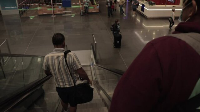 Two Man Going Down Escalators in Frankfurt Airport from the back perspective
