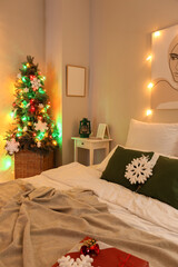 Interior of modern bedroom with Christmas tree and glowing lights