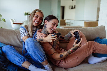 Lesbian couple playing video games at home