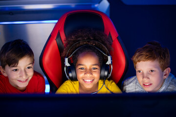 Children playing video games together on the computer.