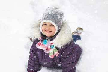 Fototapeta na wymiar Winter child in snow. Active holidays in winter. Winter Joyful Walking Happyness in white snow. Happy girl portrait in winter clothes.
