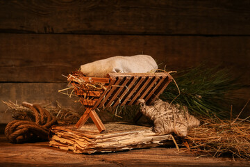 Manger with baby and old book on wooden background. Concept of Christmas story