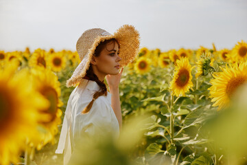 woman portrait in a white dress walking on a field of sunflowers unaltered