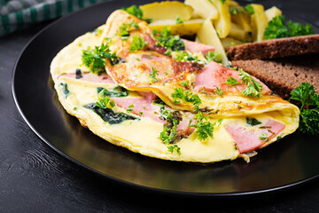 Omelet with boiled sausage and herbs, served with fermented cucumbers and bread. Rustic cuisine. Omelette.