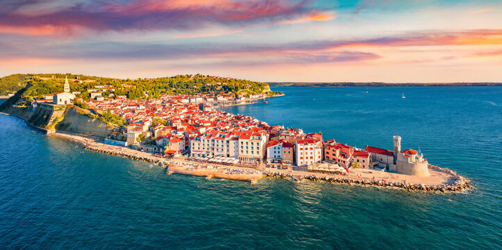 Сharm of the ancient cities of Europe. Bright morning cityscape of Piran town. Stunning summer scene of Slovenia’s Adriatic coast with beautiful Venetian architecture. View from flying drone.
