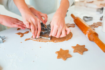 Kid's hands making gingerbread, cutting cookies of gingerbread dough. Festive food, cooking process, family culinary, Christmas and New Year traditions concept