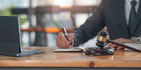 Wooden gavel on the table with attorney blurred background. Real estate concept, judge gavel or lawyer in auction with house model.