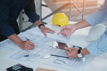 Builder two asian young engineer man construction site engineer. Engineering objects on workplace with partners interacting on background. Real-estate concept