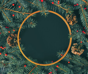 Pine twigs, pine cones, red berries and wooden circle lay down on black background. Minimal flat lay composition, Christmas and New Year elegant decorative  concept with copy space