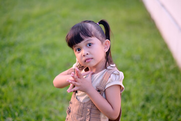 Fototapeta premium Portrait of small and cute girl with hair tied on head