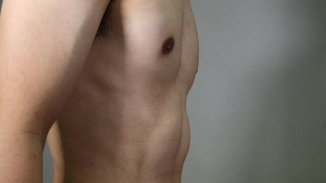 腹筋に力を入れる裸の日本人男性