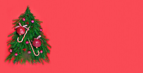 Vitamin Christmas tree. Layout in the form of a tree decorated with fresh fruits and vegetables on a red background. Vegan Christmas. Banner.