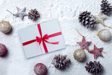 Fototapeta na wymiar Pinecone, Christmas ball, gift box, and star on the snow