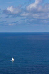 sailboat at sea sails in solitude on a sunny day. copy space, copy text. concept of freedom and opportunities