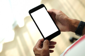 Young man sitting in living room and using smart phone.