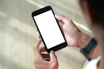 Man holding smart phone with empty screen while sitting in living room.