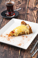 Mushroom quiche pie with tea on white plate on wooden table