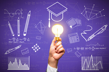 Close up of hand holding light bulb with creative knowledge and graduation sketch on purple wall...