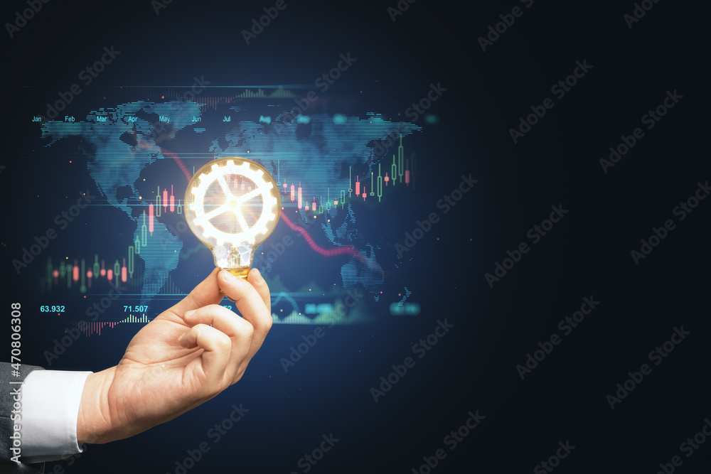 Poster close up of businessman hand holding lamp with glowing cogwheel with map, forex chart and mock up pl
