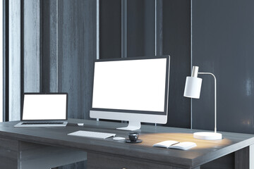 Minimalistic designer desktop with empty white computer and laptop screens in wooden interior at night. Workplace concept. Mock up, 3D Rendering.