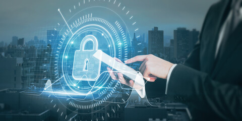 Close up of businessman hand pointing at tablet with abstract glowing padlock interface with upward chart on blurry night city background. Web security and analytics concept. Double exposure.