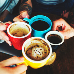 Closeup of hands holding coffee cups together