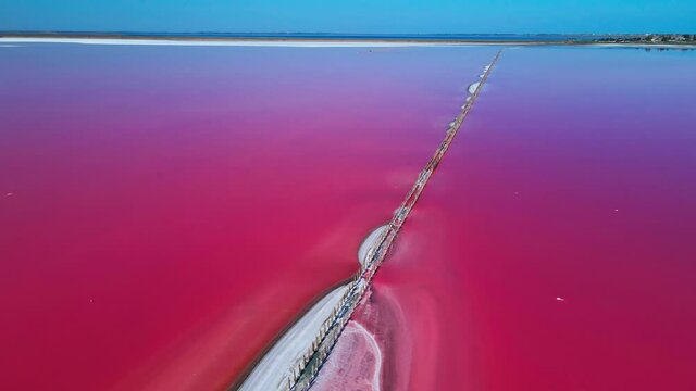Aerial top down bottom of Sivash Lemurian lake. salt lake marine origin pink red water algae bloom. Ukraine tourist mystical travel attraction. Scenic seabed pattern. Healing brine. 4k